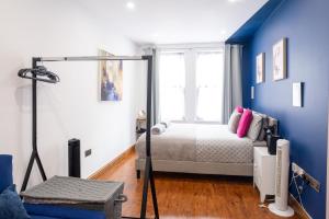 ein Schlafzimmer mit einem Bett und einer blauen Wand in der Unterkunft REEF9 - Modern central flat, 5 mins from beach, centre and Bournemouth International Centre in Bournemouth