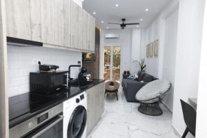 a kitchen with a washing machine and a living room at 3bd jacuzzi mansion in Athens