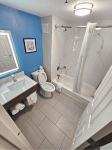 a bathroom with a sink and a toilet and a bath tub at La Quinta by Wyndham Houston Stafford Sugarland in Stafford