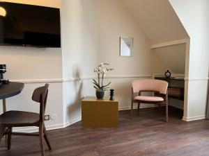 a living room with two chairs and a table at Hôtel La Truffe Noire in Brive-la-Gaillarde