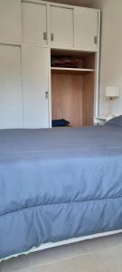 a bed with a blue blanket on top of it at El mejor lugar in Gualeguaychú