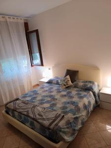 ein Schlafzimmer mit einem Bett mit einer Bettdecke darauf in der Unterkunft La casetta di Ugo in Grisignano di Zocco