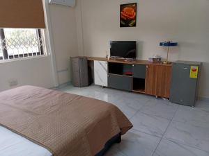 um quarto com uma cama e uma televisão num quarto em Edgard Hotel em Accra