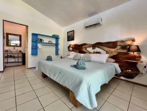 a bedroom with a large bed with a wooden headboard at Rinconcito Magico beachfront location in Punta Uva