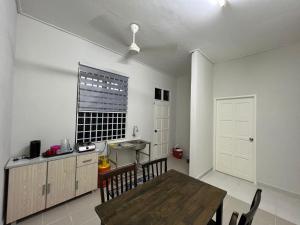 a dining room with a table and a window at Relaxs Homestay Semi-D in Bachok