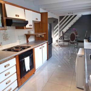 eine Küche mit weißen Schränken und einem Herd mit Backofen in der Unterkunft Crest Farm Cottage in Waterfall