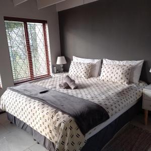 a large bed in a bedroom with a large window at Crest Farm Cottage in Waterfall +21 photos