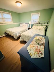 1 dormitorio con 2 camas y mesa. en Hadley Amherst Location Explore Pioneer Valley, en Hadley