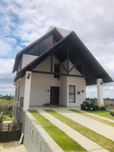 une maison blanche avec un toit noir dans l'établissement Casa em Bananeiras - Condomínio Caminhos da Serra, à Bananeiras