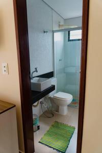 La salle de bains est pourvue de toilettes, d'un lavabo et d'un miroir. dans l'établissement Casa em Bananeiras - Condomínio Caminhos da Serra, à Bananeiras