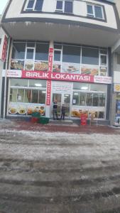 a food store with people standing in front of it at Çiftlik otel 