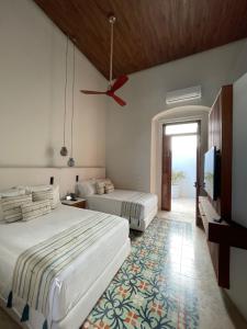 - une chambre avec 2 lits et un ventilateur de plafond dans l'établissement Las Lupitas Hotel Boutique, à Campeche