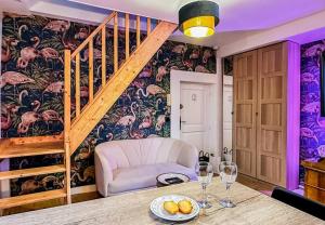 uma sala de jantar com uma escada e uma mesa com copos de vinho em Flamant Rose em Annecy