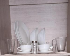 a shelf with plates and utensils and glasses at Cosmos Suites Chapinero Alto in Bogotá