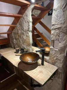 a bathroom sink with a copper bowl on a counter at DINASTIE COUNTRY APART in Villa Rumipal