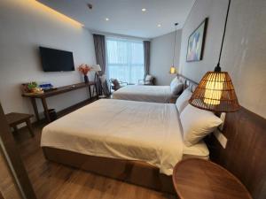 Habitación de hotel con 2 camas y TV en Apec Mandala Wyndham Mui Ne - V Ruby en Ấp Thiẹn Ái