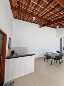 a room with a table and chairs and a counter at Casa nova e confortável próxima ao Santuário in Aparecida
