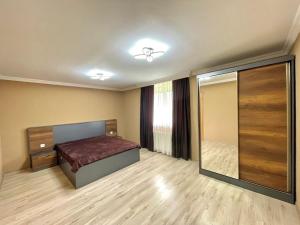 1 dormitorio con cama y espejo grande en Holiday Inn Tianeti, en Tiflis