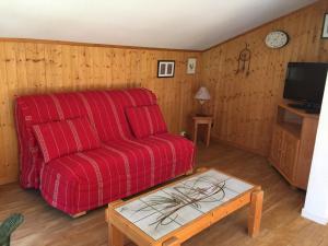 ein Wohnzimmer mit einem roten Sofa und einem Tisch in der Unterkunft Studio Chamonix-Mont-Blanc, 2 pièces, 4 personnes - FR-1-517-51 in Chamonix-Mont-Blanc