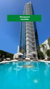 a large swimming pool in front of a tall building at Holiday Inn Rosario, an IHG Hotel in Rosario