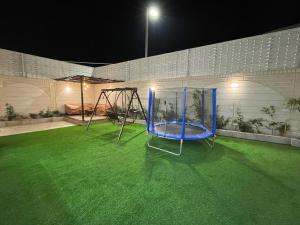 a blue playground in a yard at night at شاليهات وجدان الهدا in Al Hada