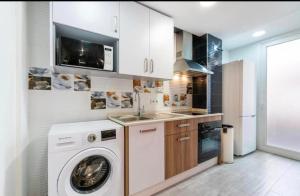 uma cozinha com uma máquina de lavar roupa e um lavatório em FANTASTICO CENTRO ESTACIONES em Málaga