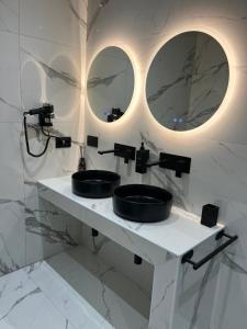 uma casa de banho com dois lavatórios e dois espelhos em Suites - ghibellina 92 em Florença