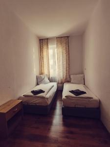 2 camas en una habitación pequeña con ventana en City Hotel Bauer mit Aufzug with elevator, en Núremberg