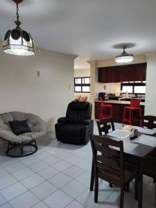 een woonkamer met een tafel en stoelen en een keuken bij Bella Vista Apartment, Oasis Residential in Santo Domingo