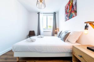 una camera con un letto bianco e una finestra di Esprit Marvel: 2 chambres- fibre- balcon- parking a Grenoble