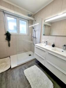 ein Bad mit einer Badewanne, einem Waschbecken und einer Dusche in der Unterkunft Large 2 Bedrooms in Center with Terrace & Parking-41b in Luxemburg (Stadt)