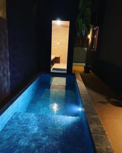a swimming pool in the middle of a house at night at Vila Manguezal, 2 suítes com opção de piscina e sauna integrada privativas na rota ecológica dos Milagres in Pôrto de Pedras