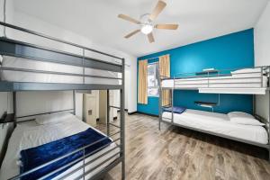 a room with two bunk beds and a ceiling fan at Samesun Hollywood in Los Angeles