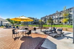 patio con tavolo, sedie e ombrellone di Quiet Apartment Central to Davis County a Clearfield