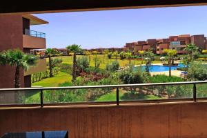 a view of a garden from a balcony of a building at Appartement de luxe (Centre proche, piscine, golf) in Marrakesh