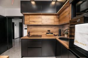 una cocina con armarios de madera y fregadero en Lotus Wellness & spa apartman en Koprivnica