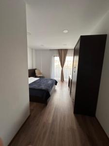 ein Hotelzimmer mit einem Bett und einem Fenster in der Unterkunft Hotel Real in Pristina