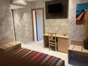 a living room with a desk and a tv on the wall at Appartement « Mexico », Avignon in Avignon