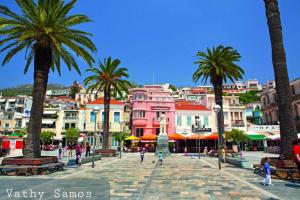 eine Stadtstraße mit Palmen und Gebäuden in der Unterkunft STUDIO ILIANA in Samos