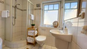 a bathroom with a sink and a toilet and a shower at Haus Eversand Nr 2 in Cuxhaven +16 photos