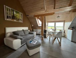 a living room with a couch and a table at Altes Siedlerhaus Nesebanz in Gustow