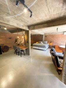 1 dormitorio con 1 cama, mesa y sillas en Pietra Rossa- Vale dos Vinhedos, en Bento Gonçalves