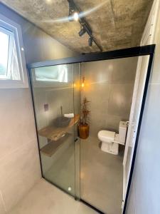 a bathroom with a glass shower with a toilet at Pietra Rossa- Vale dos Vinhedos in Bento Gonçalves