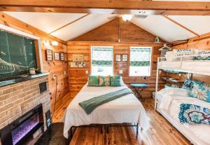 1 Schlafzimmer mit 2 Betten in einem Zimmer mit Kamin in der Unterkunft Big Blue Lake Cottages, LLC - Cottage #5 in Holton