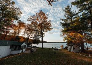 Blick auf einen See mit einem Haus und Bäumen in der Unterkunft Big Blue Lake Cottages, LLC - Cottage #5 in Holton