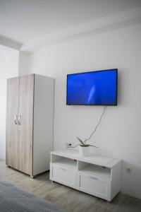 sala de estar con TV en una pared blanca en Meli apartman, en Smederevo