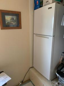 een witte koelkast in een hoek van een kamer bij George's B&B in Lewiston