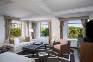 a living room with a couch and chairs and windows at The Ritz-Carlton New York, Central Park in New York