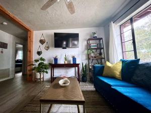 - un salon avec un canapé bleu et une table dans l'établissement 3BR Downtown House with Yard by UF, à Gainesville