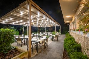 a restaurant with tables and chairs under a pergola at Hotel & Relax Zone Cattleya in Krushuna